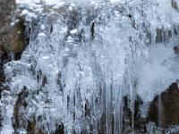 Eiszapfen Gruppe über Eiswulst an Bachkaskade